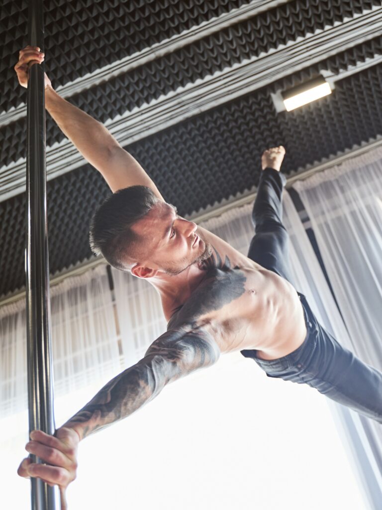 homme réalisant un iron X en école de pole dance